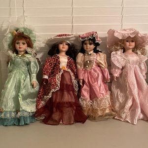 Four porcelain dolls in beautiful dresses and hats